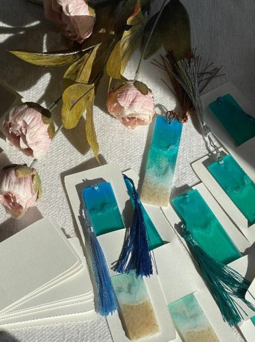 Image of ocean-inspired resin bookmarks featuring intricate designs reminiscent of waves, and sand, perfect for book lovers seeking coastal charm in their reading experience.