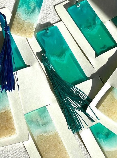 Image of ocean-inspired resin bookmarks featuring intricate designs reminiscent of waves, and sand, perfect for book lovers seeking coastal charm in their reading experience.