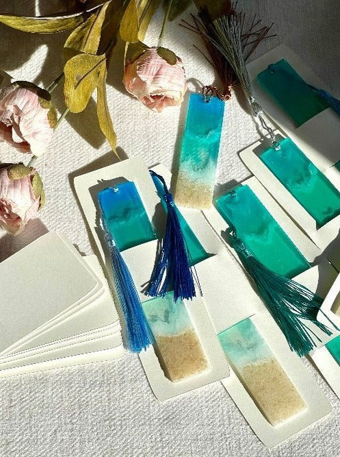 Image of ocean-inspired resin bookmarks featuring intricate designs reminiscent of waves, and sand, perfect for book lovers seeking coastal charm in their reading experience.