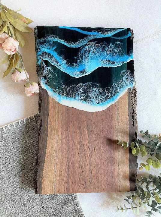 Live edge black walnut charcuterie board featuring resin art with ocean wave design