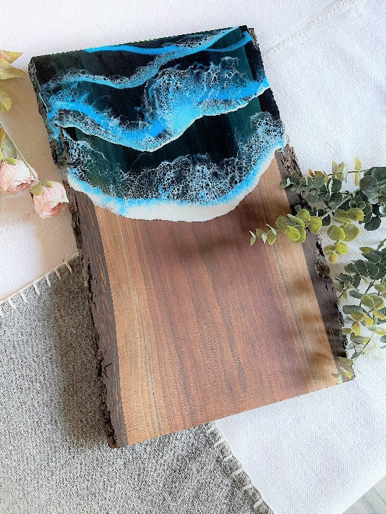 Live edge black walnut charcuterie board featuring resin art with ocean wave design