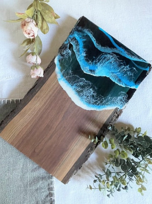 Live edge black walnut charcuterie board featuring resin art with ocean wave design