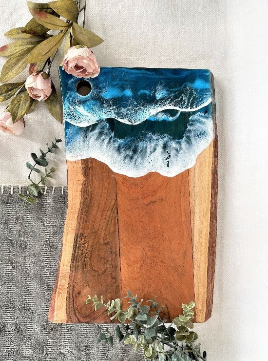 Live edge acacia charcuterie board wood slab with resin art ocean waves.