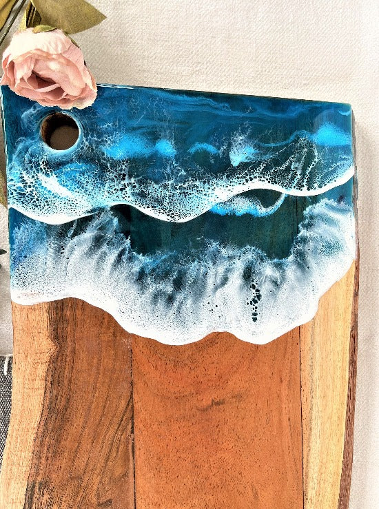 Live edge acacia charcuterie board wood slab with resin art ocean waves.