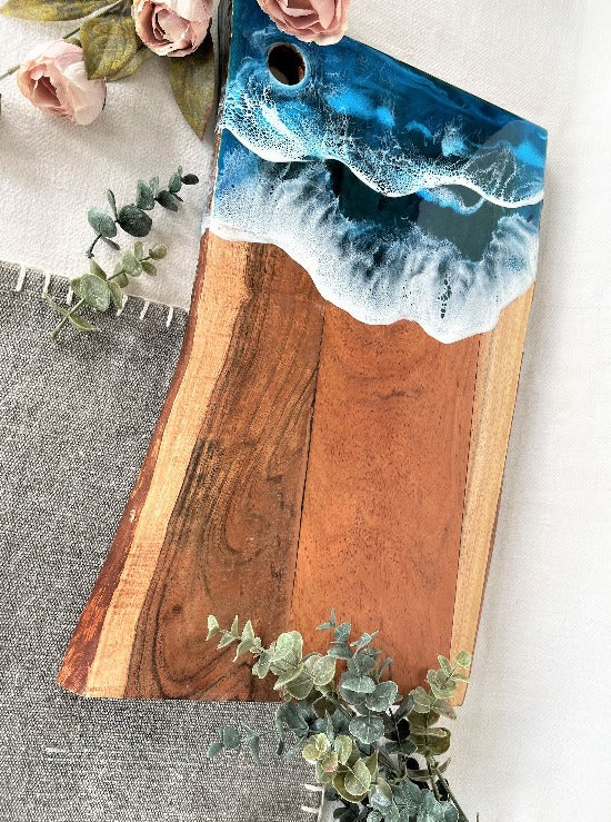 Live edge acacia charcuterie board wood slab with resin art ocean waves.