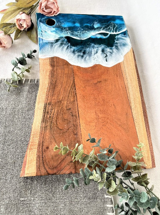 Live edge acacia charcuterie board wood slab with resin art ocean waves.