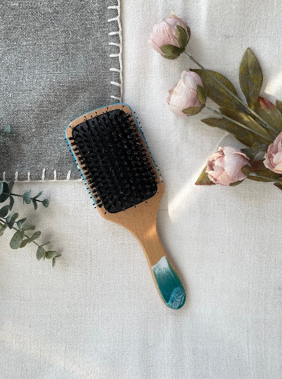 Handcrafted hairbrush featuring resin art with swirling ocean waves design.