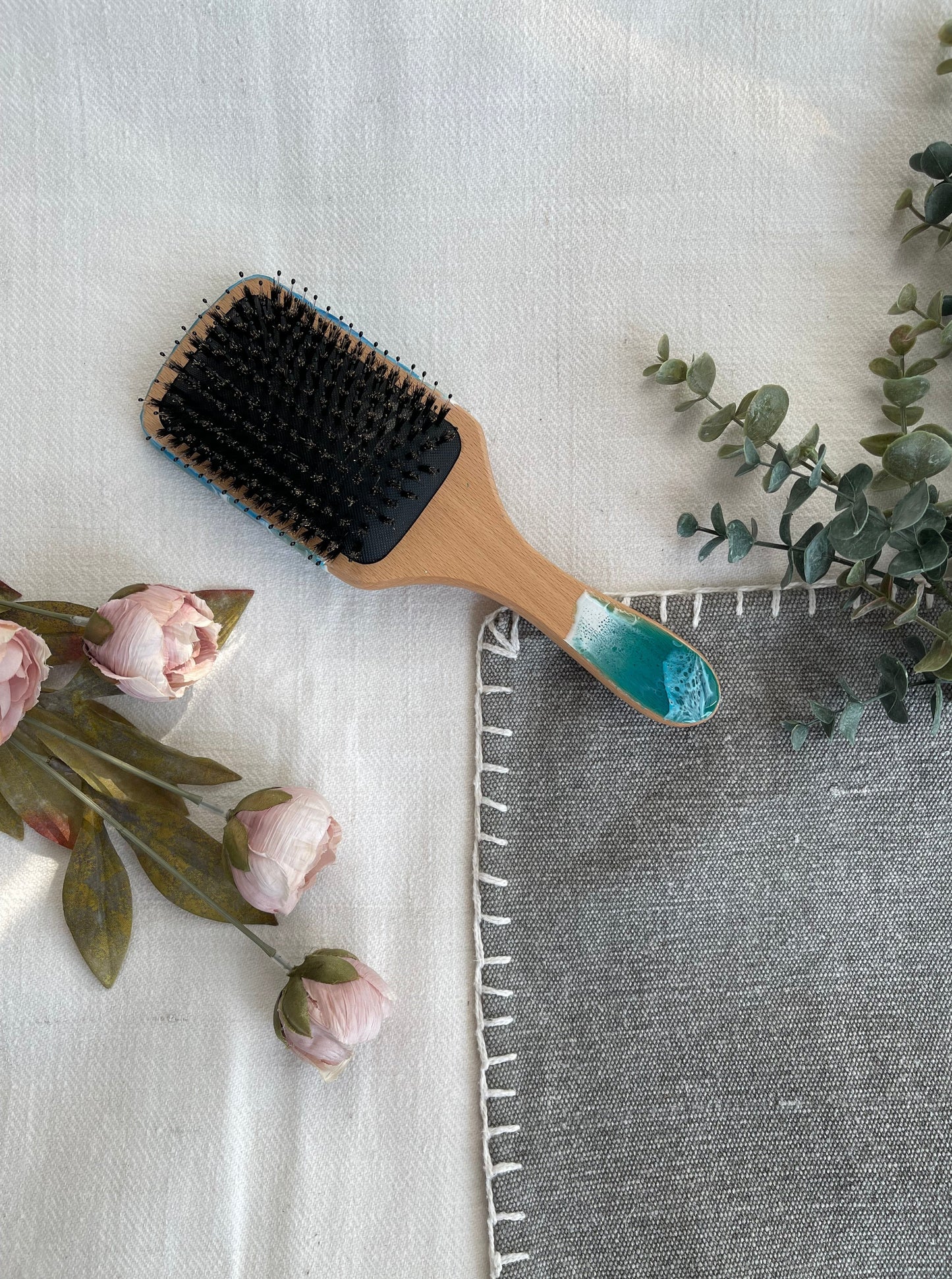 Handcrafted hairbrush featuring resin art with swirling ocean waves design.