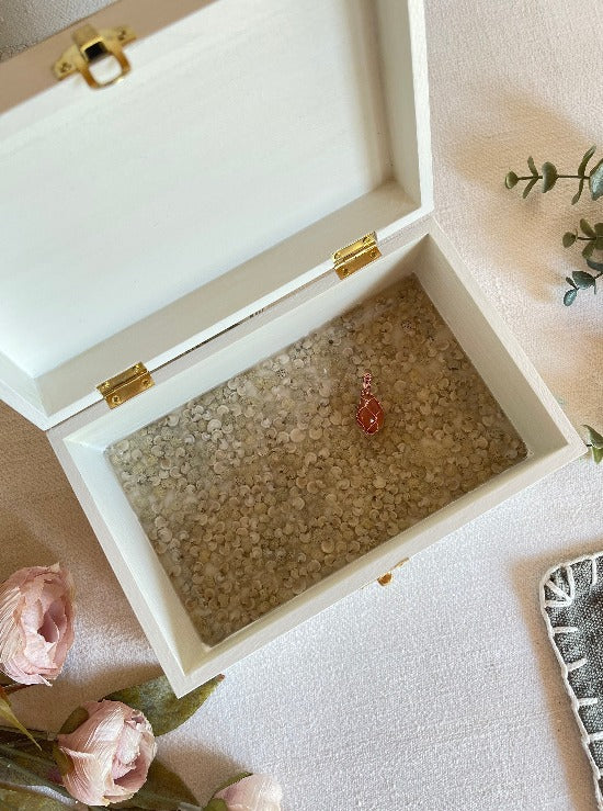 Hand-painted wooden box adorned with resin art depicting ocean waves, seashells, and sand, a unique and artistic product.